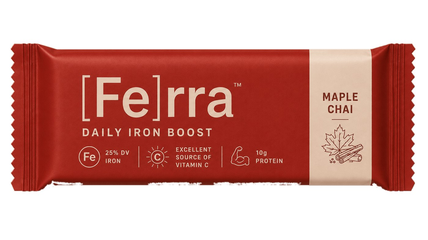 A Ferra Maple Chai bar in a deep red wrapper. The cream wordmark reads [Fe]rra, with Daily Iron Boost beneath it, and callouts for 25% DV iron, excellent source of vitamin C, and 10g protein.